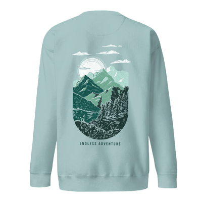 Image of a light blue crewneck with the Winnebago logo on the front and a landscape illustration on the back